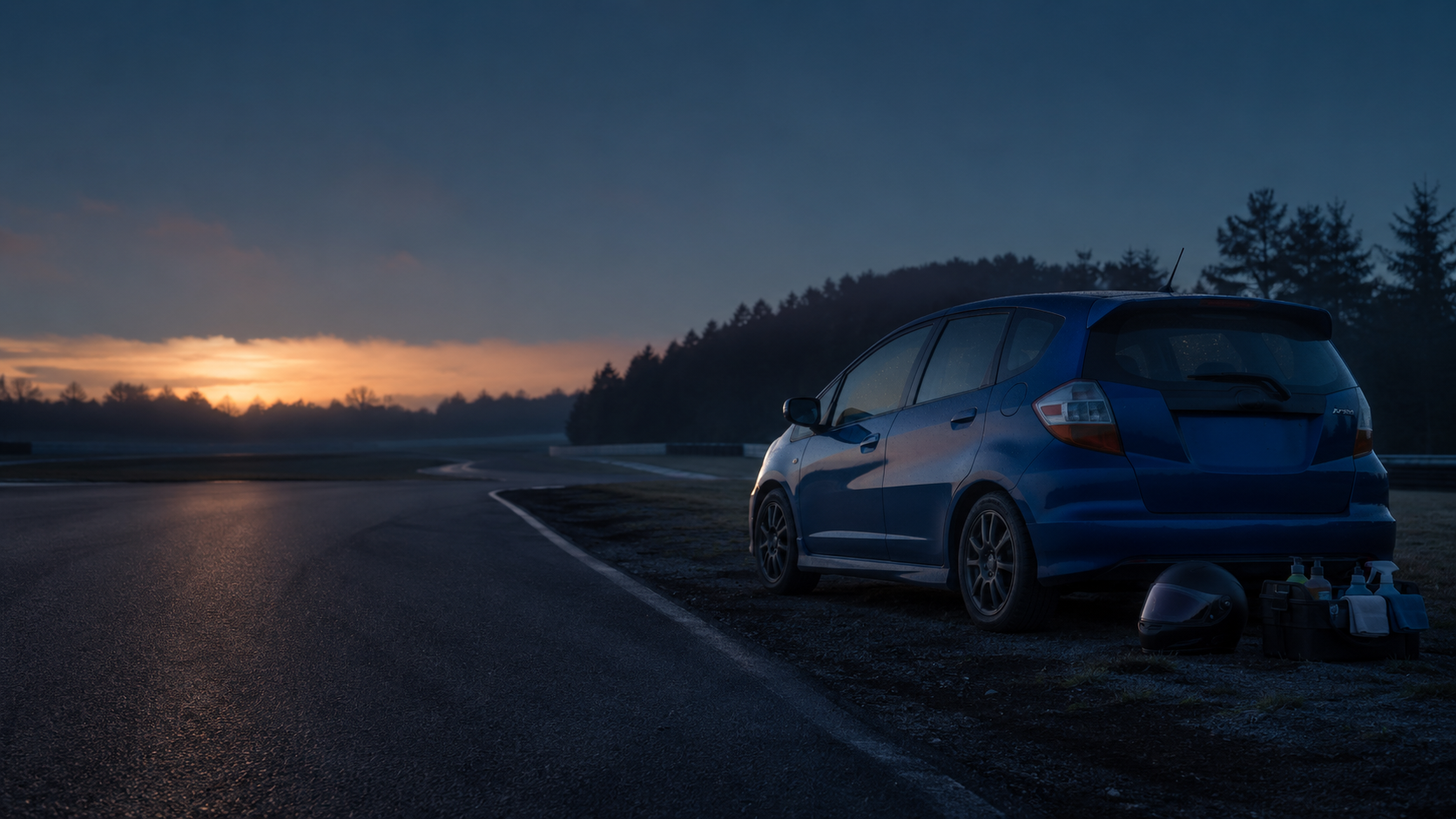 Honda Fit parked beside a track at dawn
